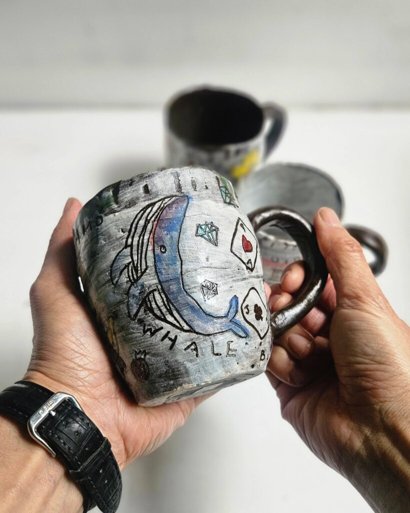 Froy series nerikomi mug with whale illustration, held in two hands